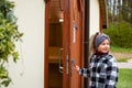 The girl opens the old wooden door and looks back Royalty Free Stock Photo