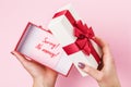 Girl opens a box with a gift on a pink background. Concept on the topic of lack of money to buy gifts Royalty Free Stock Photo