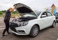 The girl opens the hood of a new car Lada Vesta