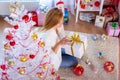 Girl opens New Year`s gift at the Christmas tree