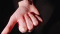 Girl opens fist with ring in it. Black background