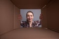 A girl opens a parcel or gift, a photo taken through a box Royalty Free Stock Photo