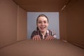 A girl opens a parcel or gift, a photo taken through a box Royalty Free Stock Photo