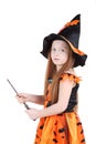 Girl in orange costume of witch for Halloween holds wand