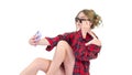 Girl takes a selfie,a beautiful girl in a shirt and with a phone in his hand,on a white background,close-up. Royalty Free Stock Photo