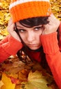 Girl in orange hat on leaves. Autumn depression. Royalty Free Stock Photo