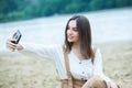 Girl outdoors texting on her mobile phone. Girl with phone. Portrait of a happy woman text sms message on her phone. Royalty Free Stock Photo