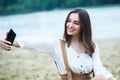 Girl outdoors texting on her mobile phone. Girl with phone. Portrait of a happy woman text sms message on her phone. Royalty Free Stock Photo