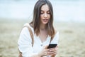 Girl outdoors texting on her mobile phone. Girl with phone. Portrait of a happy woman text sms message on her phone. Royalty Free Stock Photo