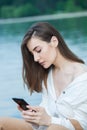 Girl outdoors texting on her mobile phone. Girl with phone. Portrait of a happy woman text sms message on her phone. Royalty Free Stock Photo