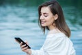 Girl outdoors texting on her mobile phone. Girl with phone. Portrait of a happy woman text sms message on her phone. Royalty Free Stock Photo