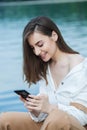 Girl outdoors texting on her mobile phone. Girl with phone. Portrait of a happy woman text sms message on her phone. Royalty Free Stock Photo