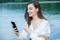 Girl outdoors texting on her mobile phone. Girl with phone. Portrait of a happy woman text sms message on her phone. Royalty Free Stock Photo