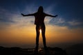 Girl with outstretched hands at sunset silhouette