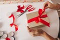 Girl packing golden box with red bow on the white background for christmas or new year gifts. Happy Christmas concept Royalty Free Stock Photo