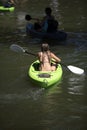 Girl with paddle riding on the lake in kayak along with other people resting Royalty Free Stock Photo