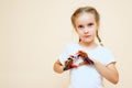 Girl with painted hands showing heart