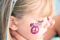 Girl with painted peace sign on face Royalty Free Stock Photo