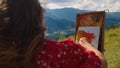 Girl painter drawing meadow close up. Woman painting using easel in mountains. Royalty Free Stock Photo