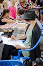 girl painter draws a pencil of portrait of a woman on a city holiday