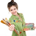 Girl painter holding brushes and palette with oil paints and happy smiling,  professional painter at work Royalty Free Stock Photo