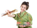 Girl painter holding brushes and palette with oil paints and happy smiling,  professional painter at work Royalty Free Stock Photo