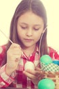 Girl paints easter eggs