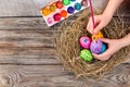 Girl paints Easter eggs.