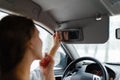 A young girl puts make-up in the car.