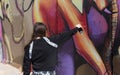 A girl paints a picture with a color spray on a concrete security fence on the border between Israel and Lebanon.