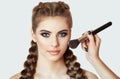 The Girl paints powder on the face, completes the smokey eyes make-up in the beauty salon. Professional skin care