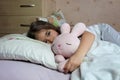 Girl in pajama sleeping and hugging her toy hare