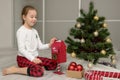 girl in pajamas near the Christmas tree throws a letter to Santa in the mailbox, Christmas gifts Royalty Free Stock Photo