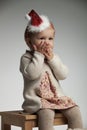 Girl with palms over her mouth is expecting santa claus Royalty Free Stock Photo