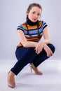 Girl in pants and a rainbow t-shirt squatting Royalty Free Stock Photo