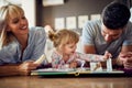 Girl with parents playing and eating banana