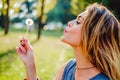 Girl in a park blowing dandelion