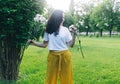 A girl in the park near a large bush sniffs a bouquet of daisies. Good luck, happy pastime, good mood. The concept of healthy Royalty Free Stock Photo