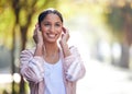 Girl, park and outdoor with sportswear, earphones and fitness in nature, smile and exercise in woods. Wellness, city and Royalty Free Stock Photo