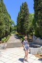 Girl on a park path amid high cypress trees Royalty Free Stock Photo