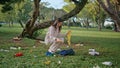 Girl park pollution cleanup collecting plastic organic waste from green grass. Royalty Free Stock Photo