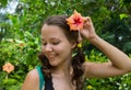 Girl in park smiling and covering face with flower Royalty Free Stock Photo