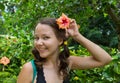 Girl in park smiling and covering face with flower Royalty Free Stock Photo