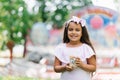 girl in the park in the summer is holding popcorn in her hands and smiling with a wide smile