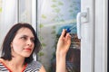 Girl parses the handle for PVC window using a screwdriver.