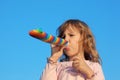 Girl with party blower on blue sky Royalty Free Stock Photo
