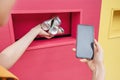 Girl passes aluminum cans for recycling and looks at the smartphone screen with a special eco app