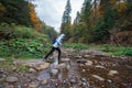 Girl passes over rocks mountain stream
