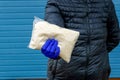 The girl passes rice at arm`s length in a glove. Help during a pandemic. Donations of food or the concept of food delivery