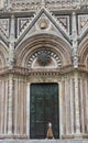 A girl passing by the door of Siena Cathedral